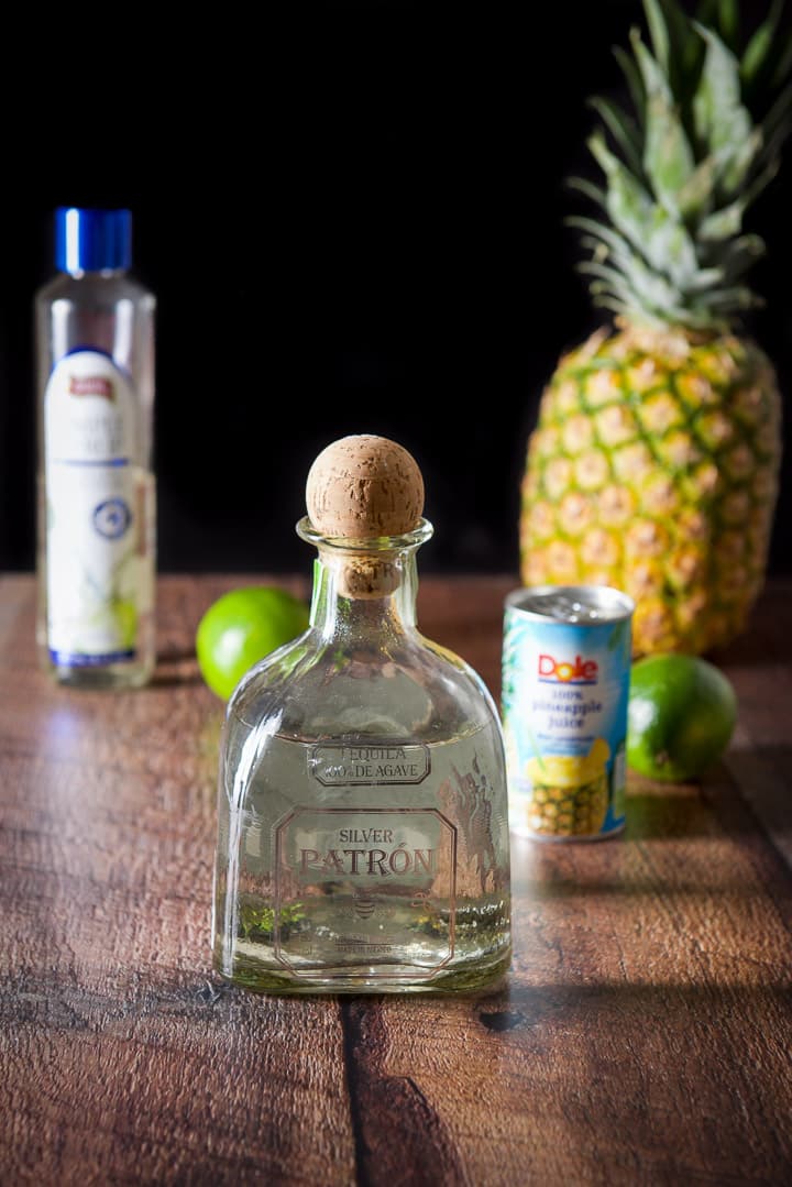 Tequila, limes, pineapple juice, simple syrup and a pineapple in the background