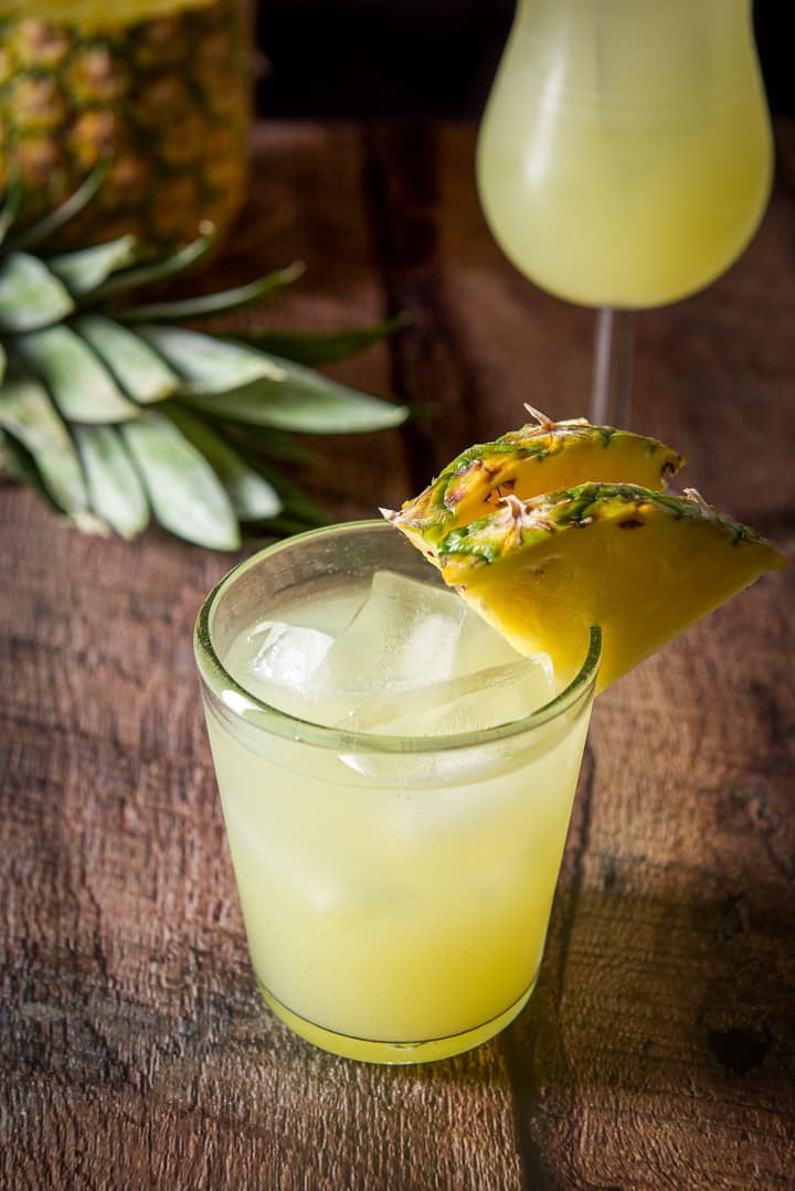 Close up of the matador in a double old fashioned glass with some pineapple in the background