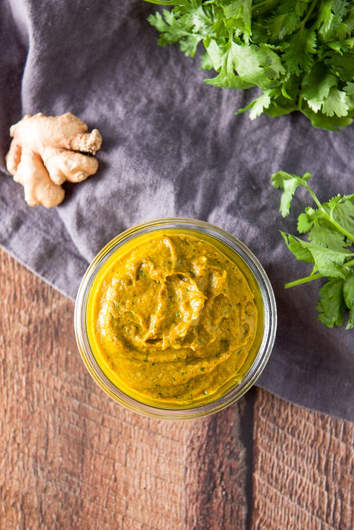 Overhead view of the paste in a jar on a napkin with cilantro and ginger
