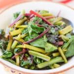 A brown and white bowl filled with the greens
