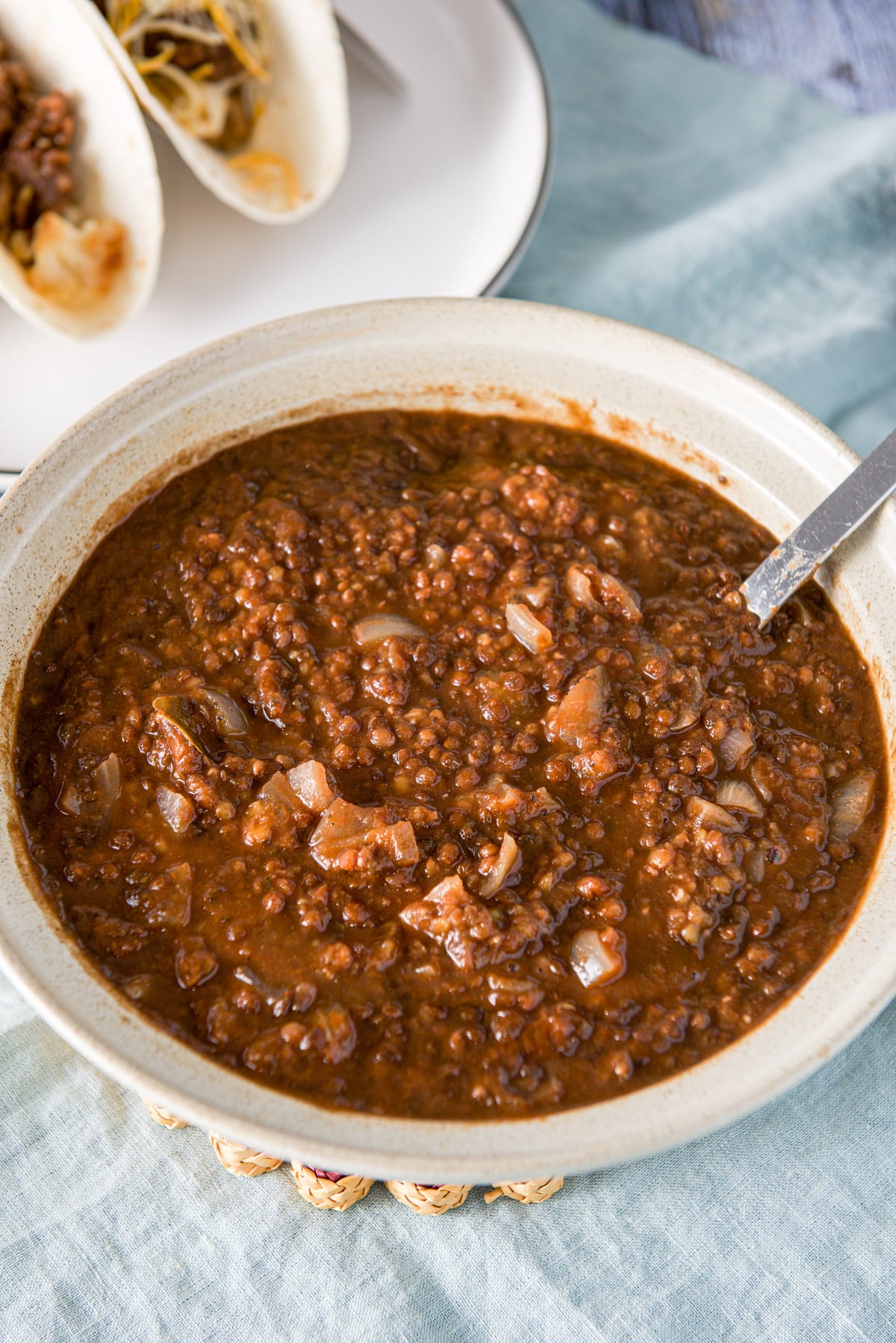 A big bowl filled with lentils with the tacos off to the side