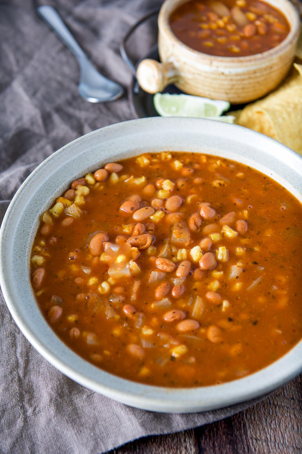 A big bowl with the posole soup in it, with a crock full of the soup in the back