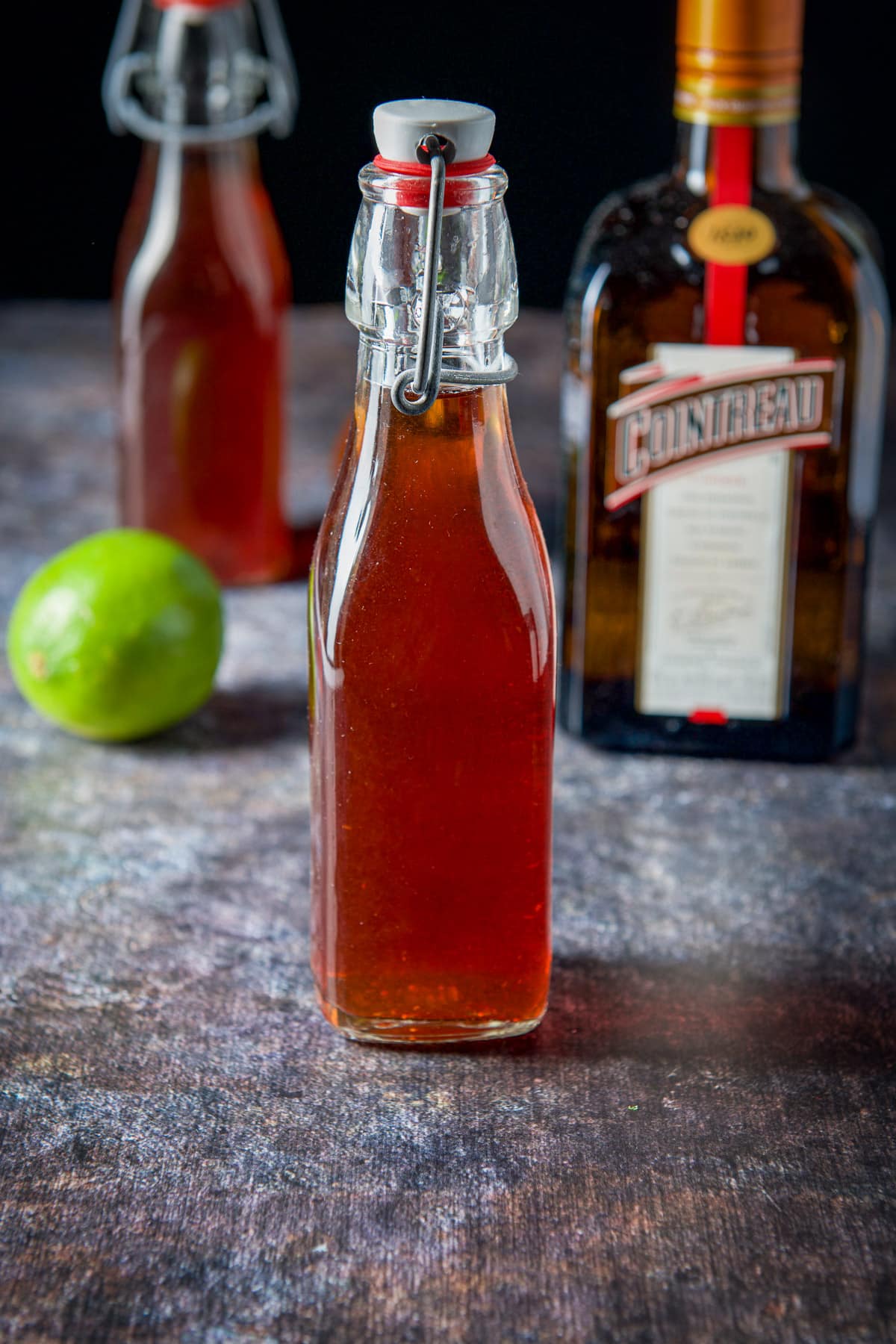 Bottle of strawberry vodka, cointreau and a lime