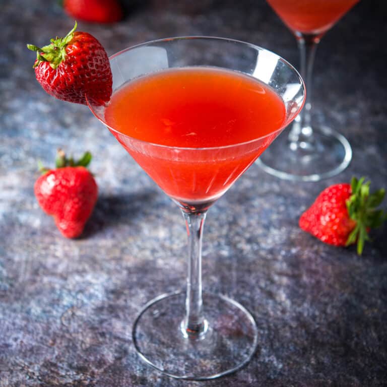 The strawberry cosmo with a strawberry on the rim and table