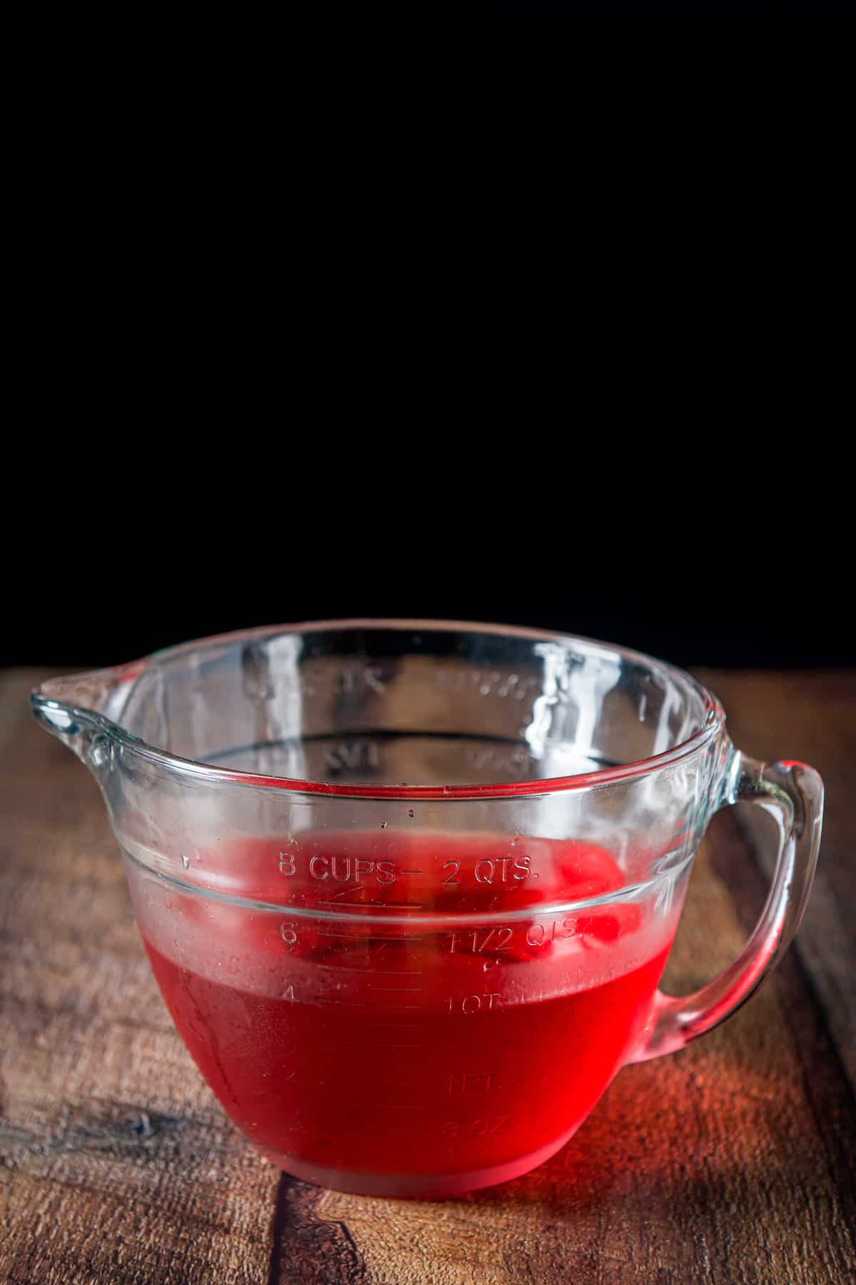 A big glass bowl with the raspberry vodka in it
