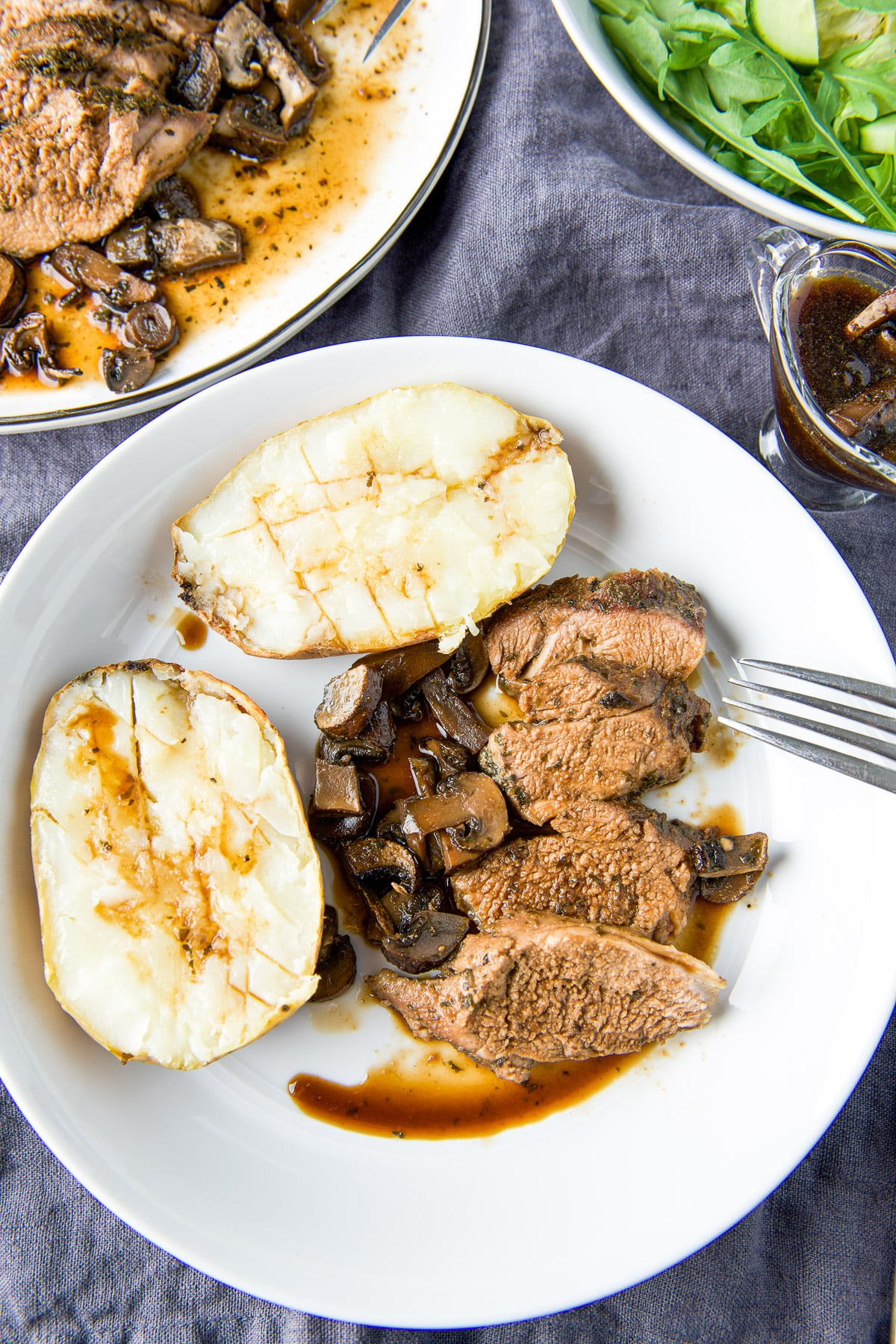 Overhead view of the tenderloin with mushrooms and a baked potato