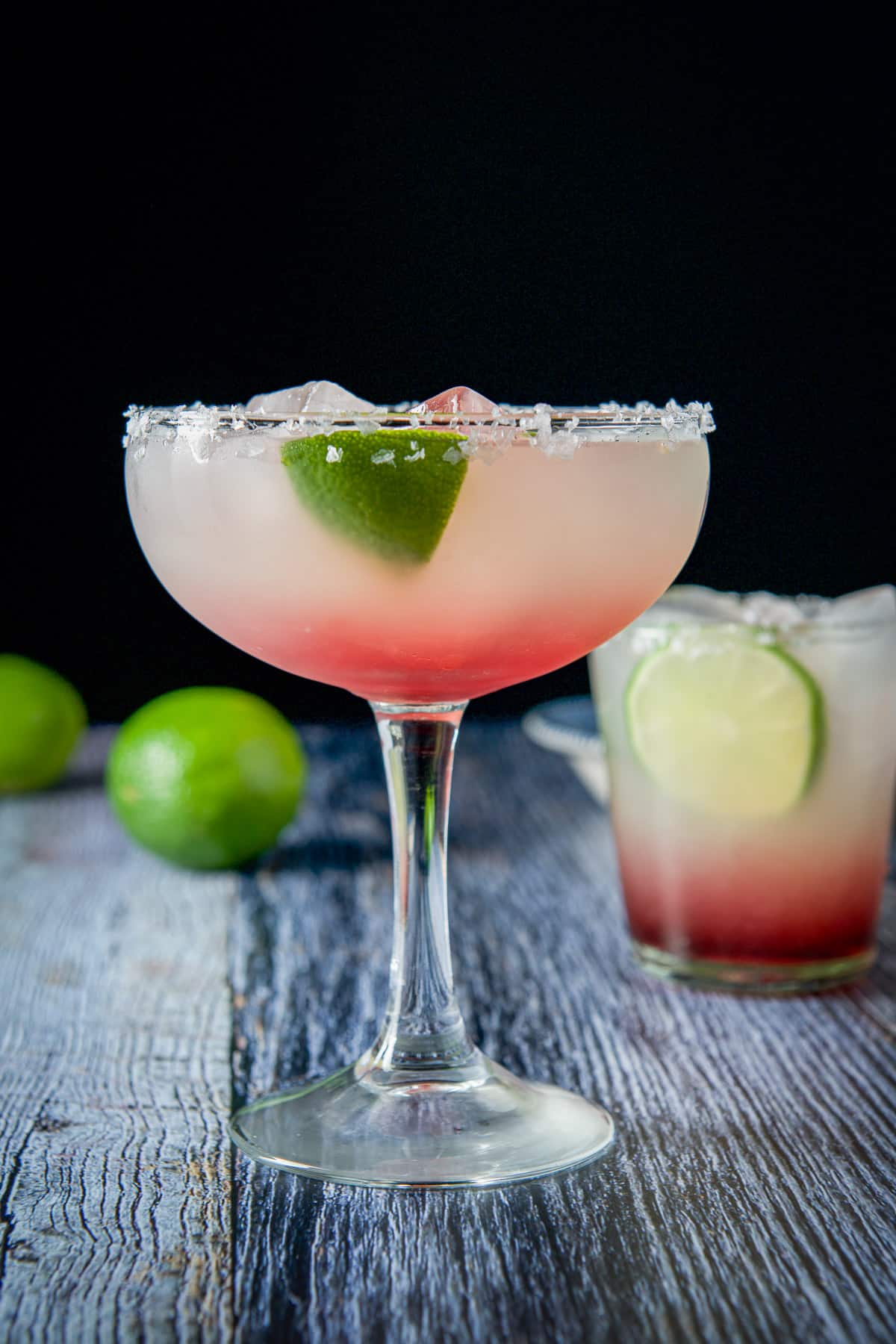 Vertical view of the raspberry margarita in both a bowl glass and old fashioned glass