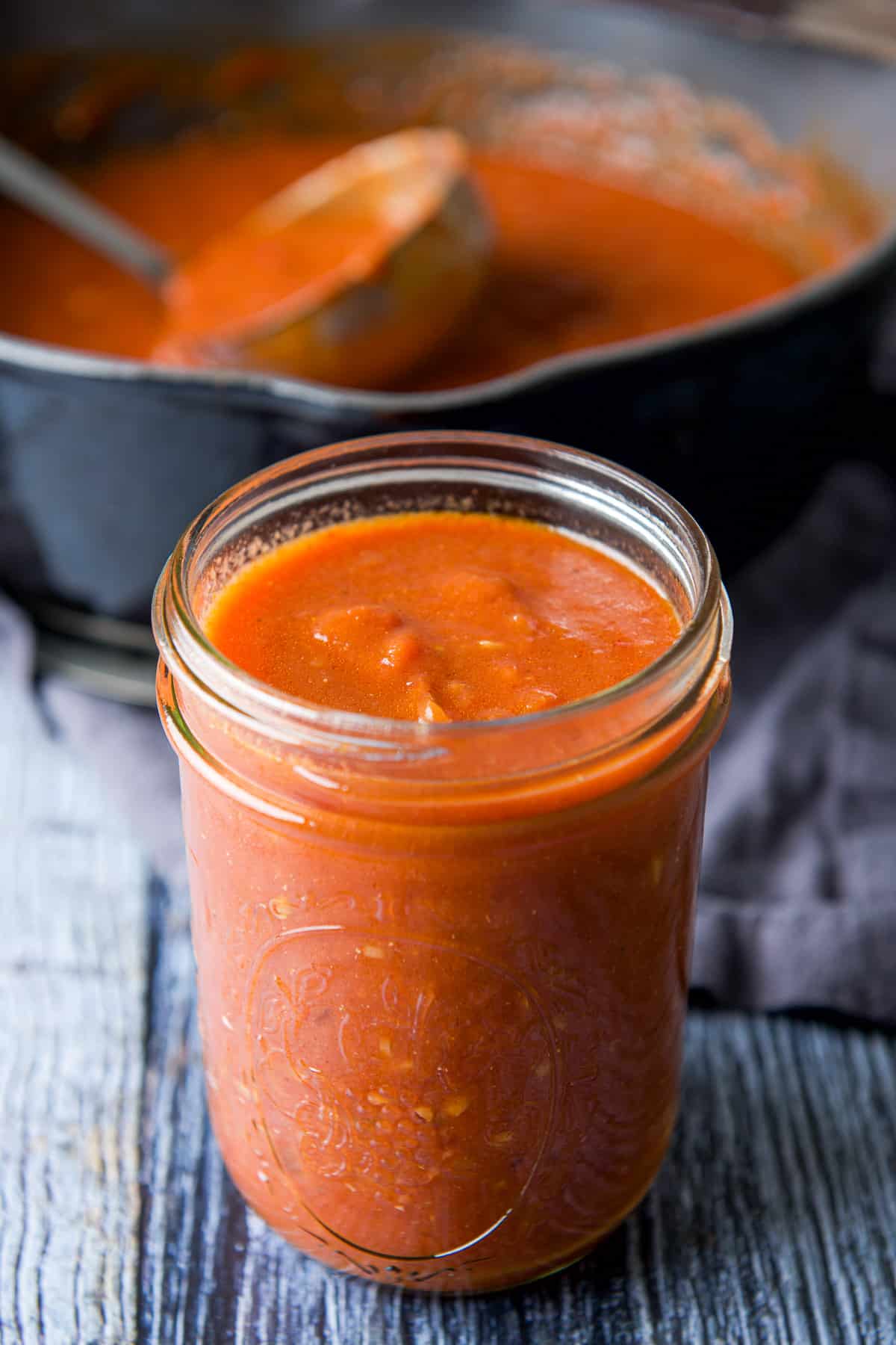 Jar of vodka sauce with the pan in the background