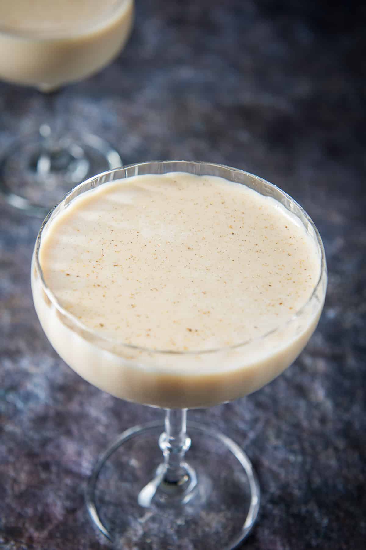 Close up of the fluted glass filled with the cream cocktail with nutmeg on top
