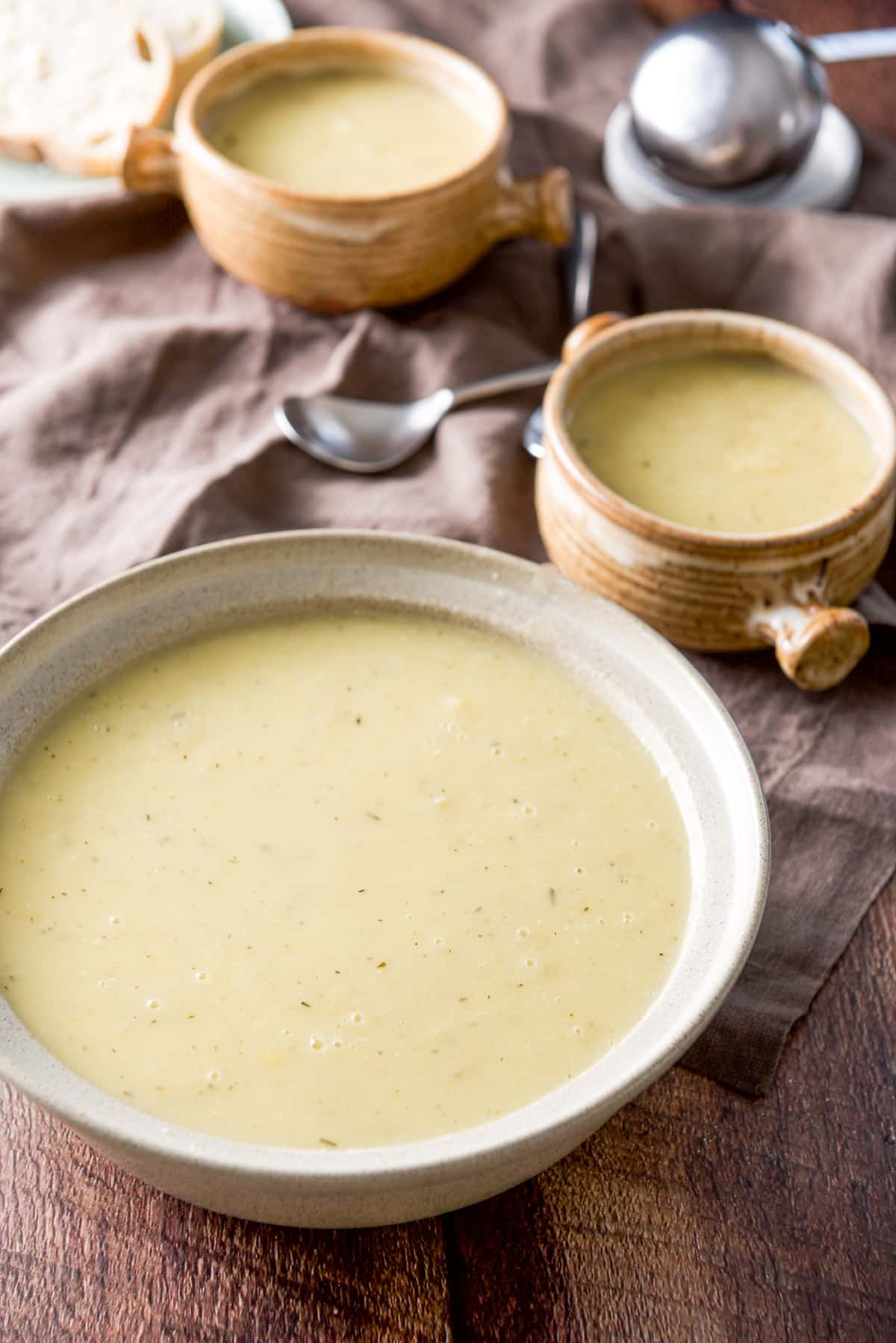 A big bowl of potato soup and two crocks in the back
