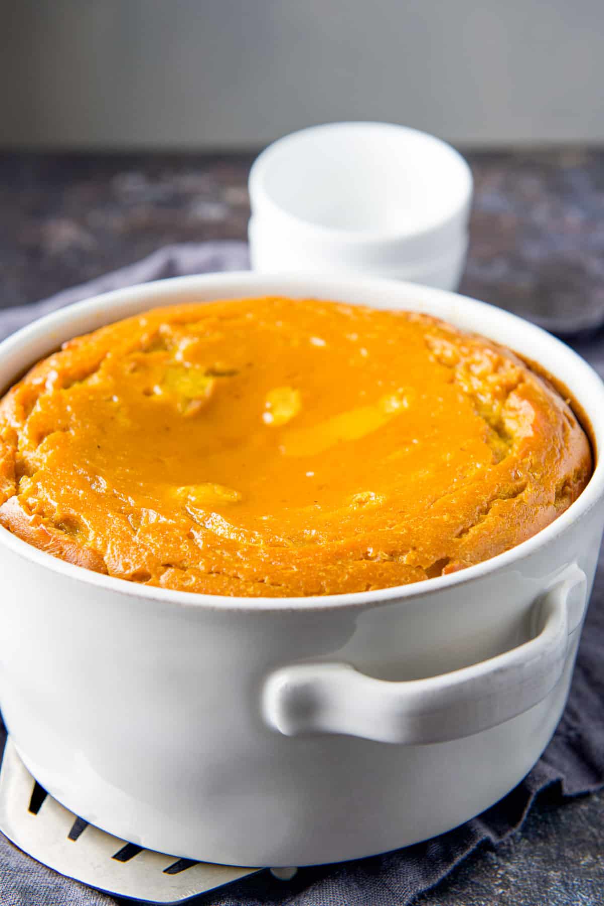 The squash souffle fresh out of the oven with two small bowls in the back