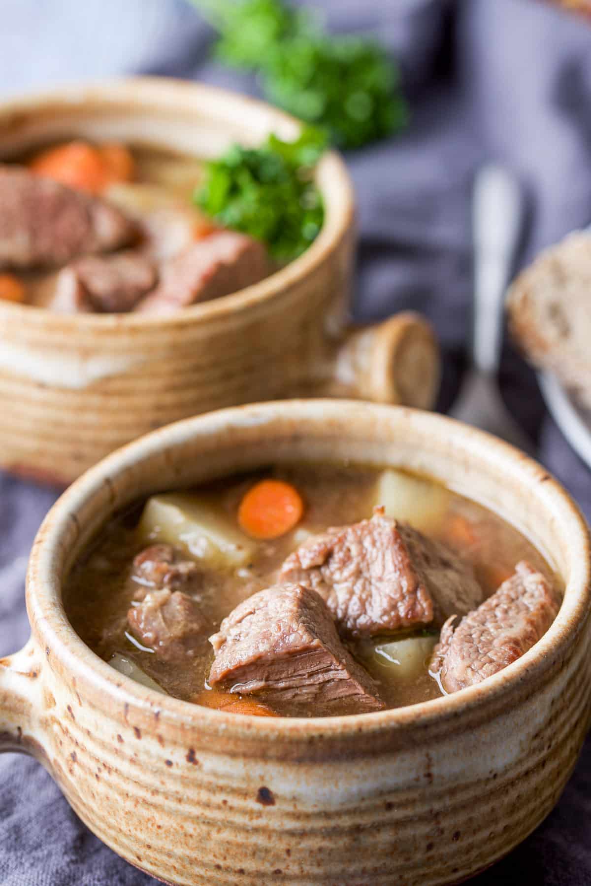 Two crocks of lamb stew with fresh herbs
