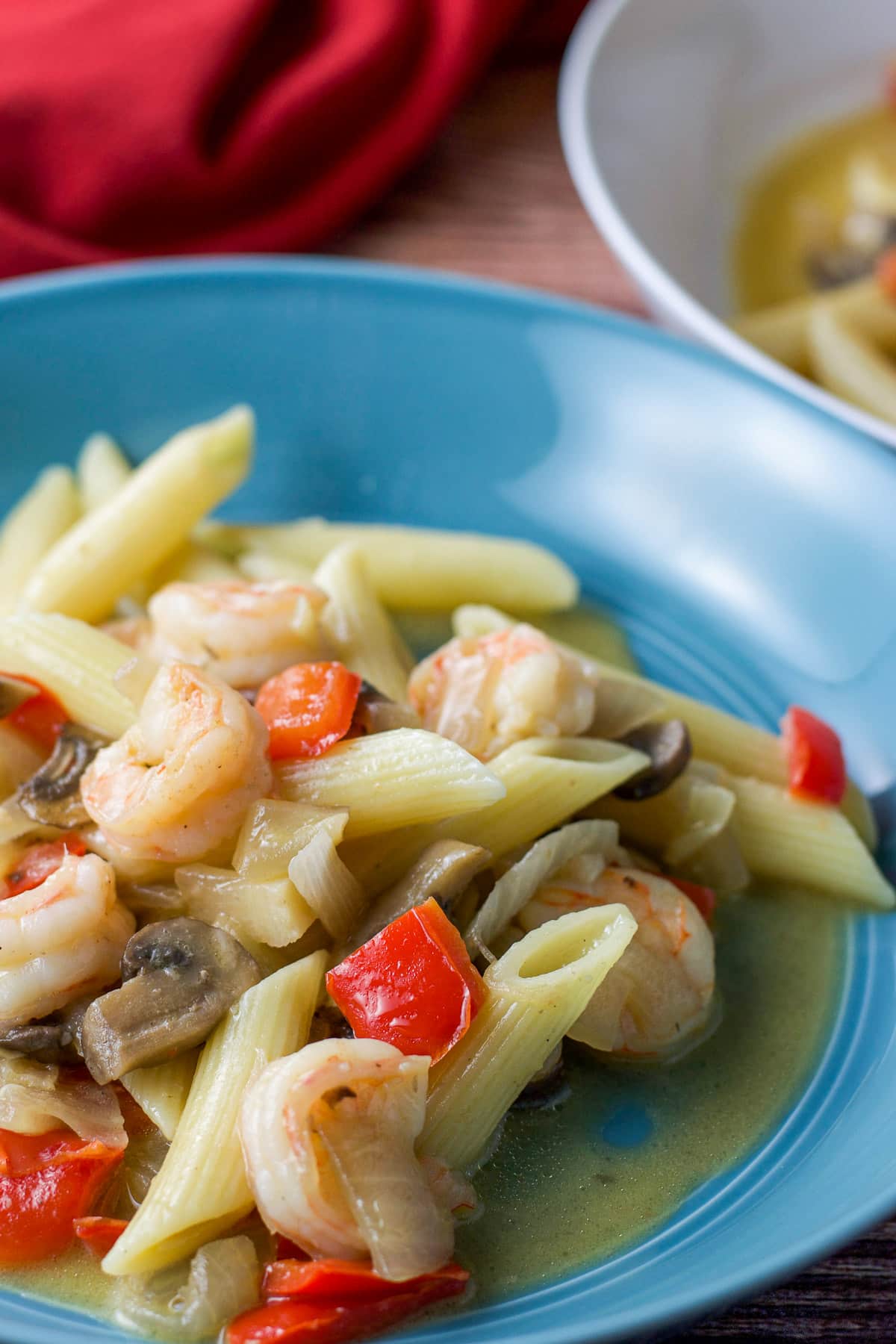 Close up of the shrimp and pasta dish in a blue plate