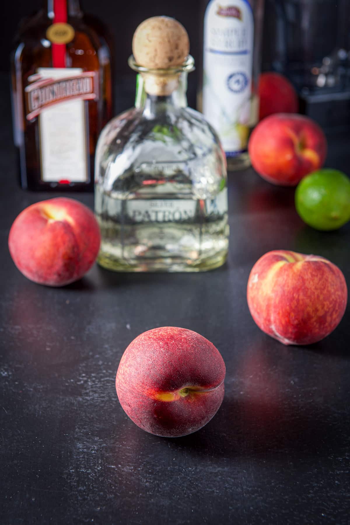 Peaches, tequila, cointreau, lime, and simple syrup on the table