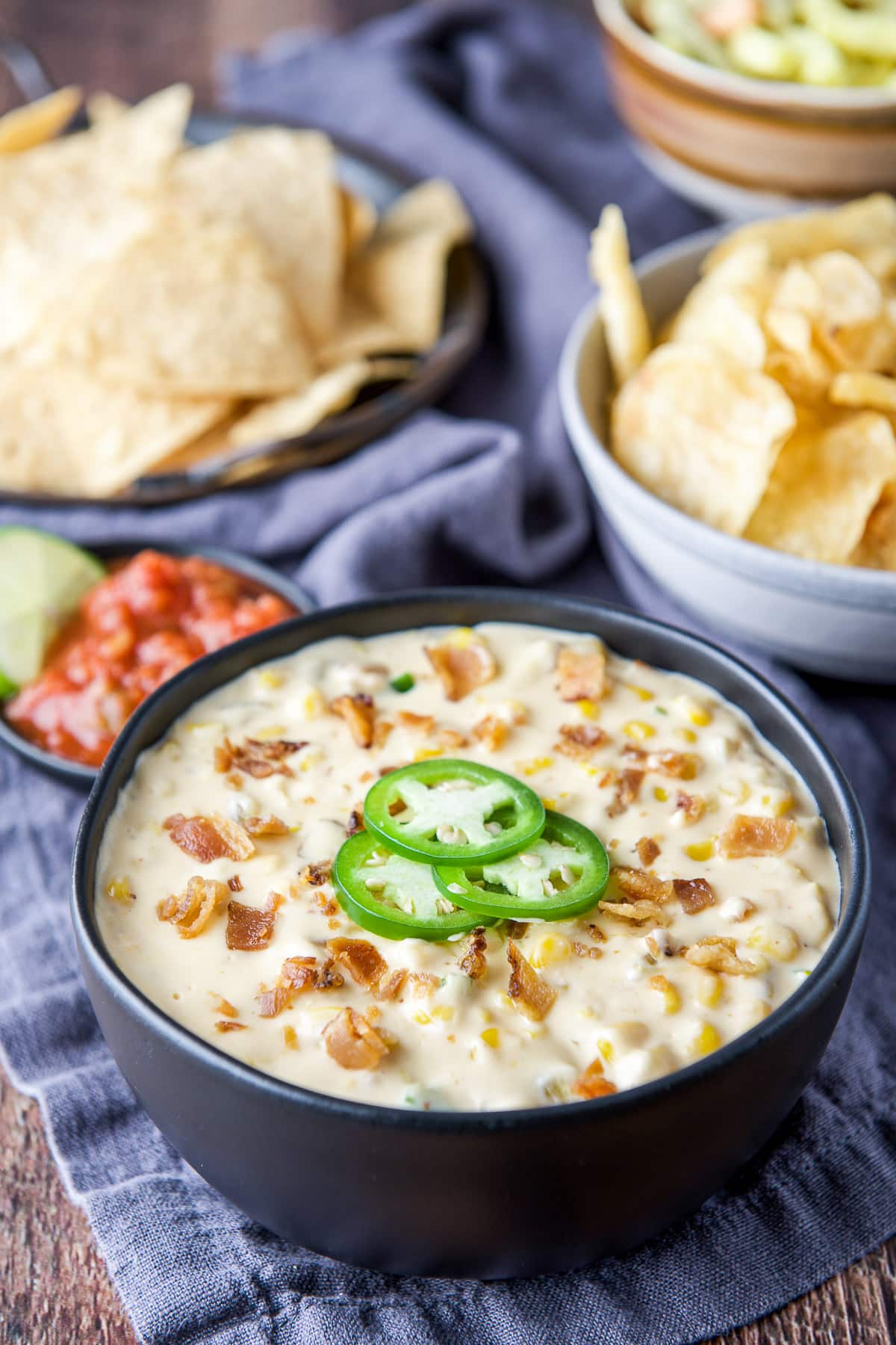 Jalapenos added to the corn dip with bacon bits on top and chips in the back