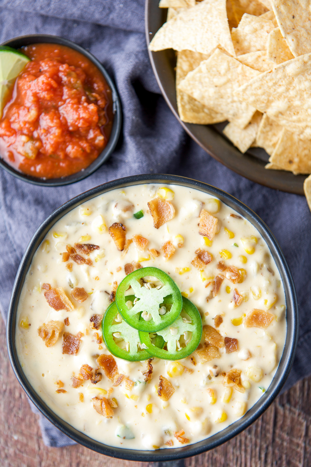 Overhead view of dip with jalapeno wheels, salsa and chips