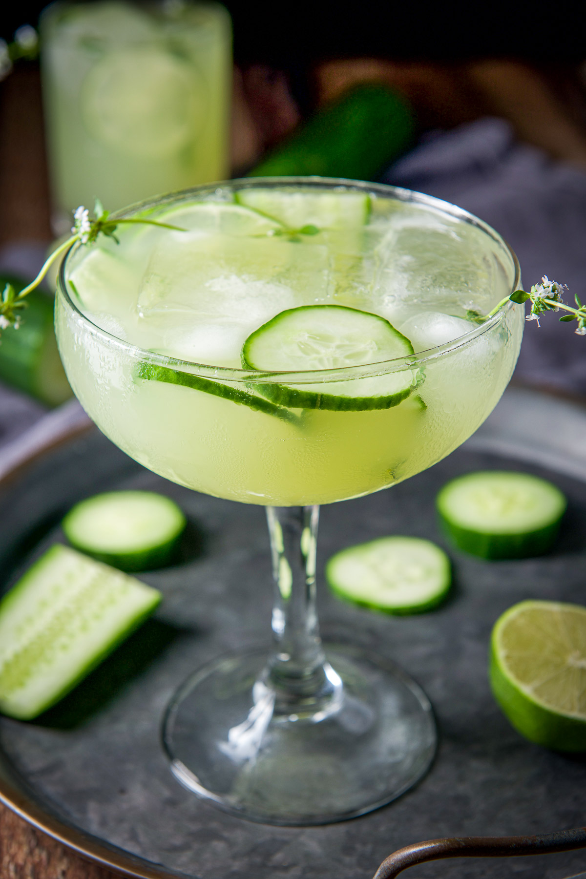 Close view of the bowl glass with the martini in it with cucumber and lime as garnish