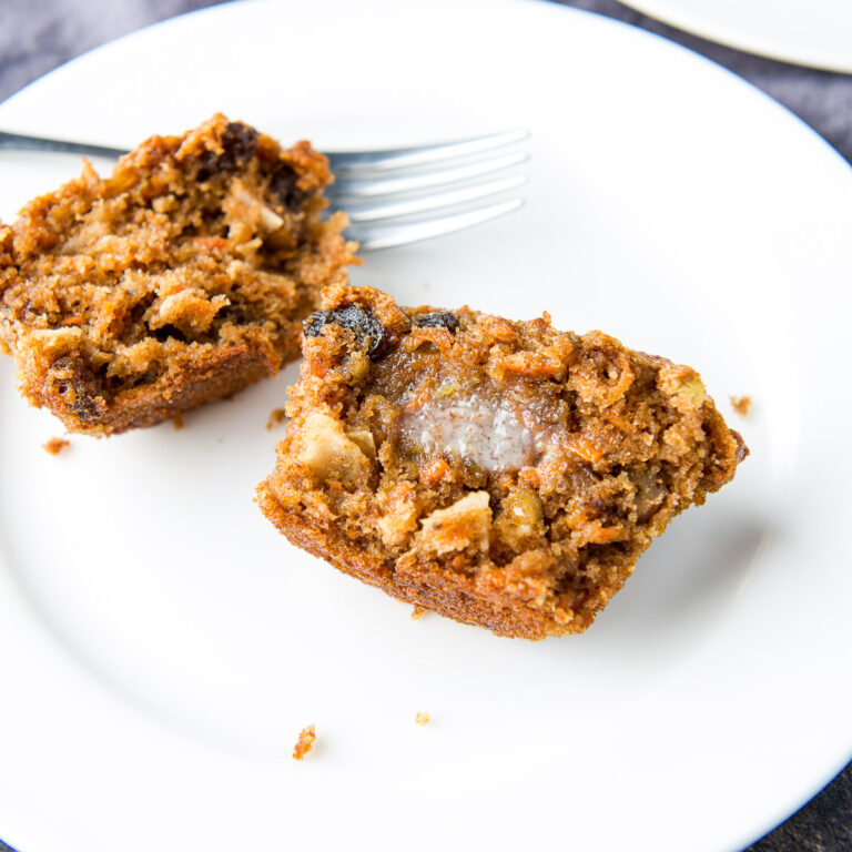 square photo of a muffin slathered with butter on a white plate