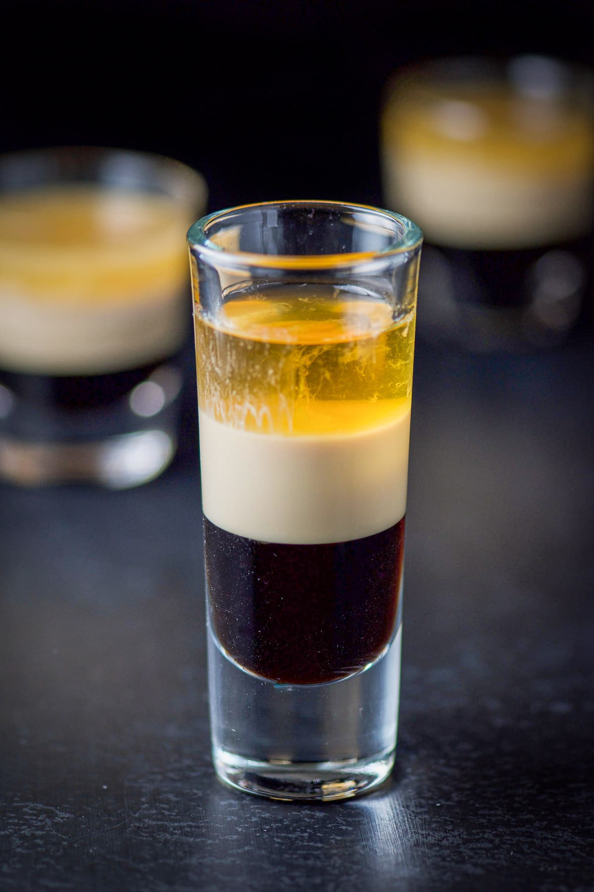 The three layers of the shot shown in the tall glass