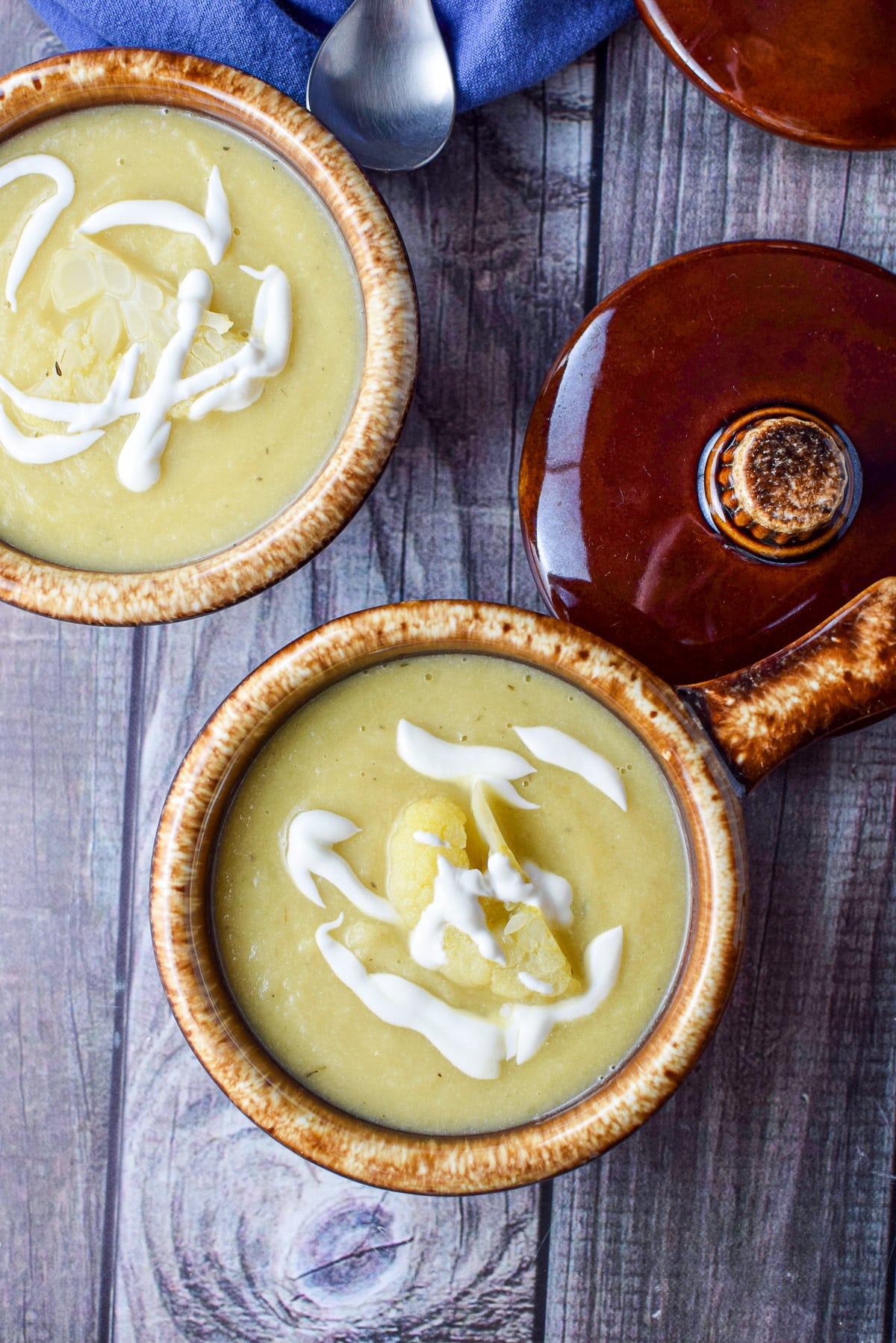 Overhead view of two crocks of soup with a white drizzle on the soup