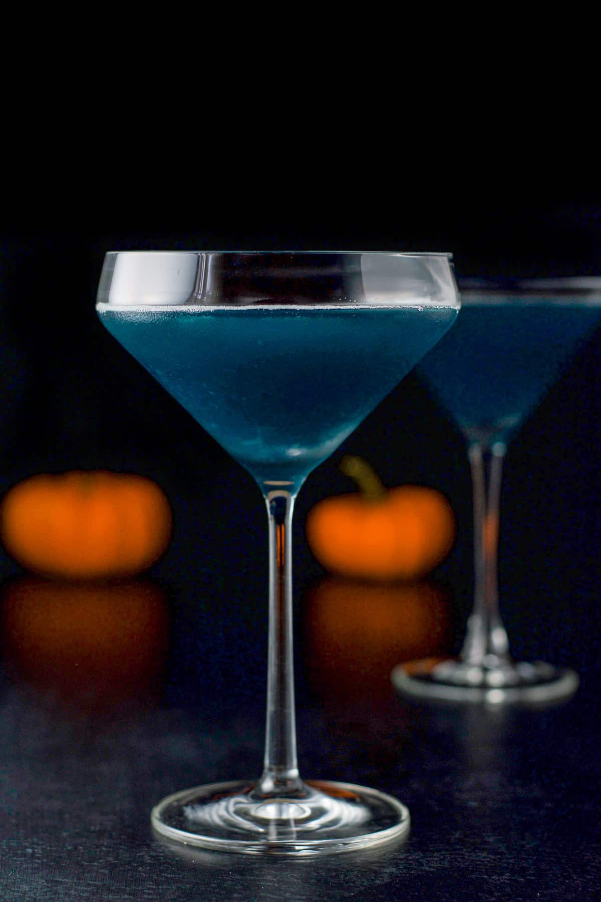 vertical view of the blue drink in the martini glasses