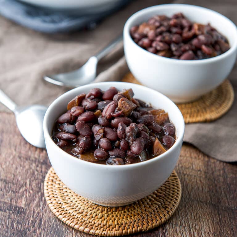 Square photo of two little bowls filled with black beans and carrots