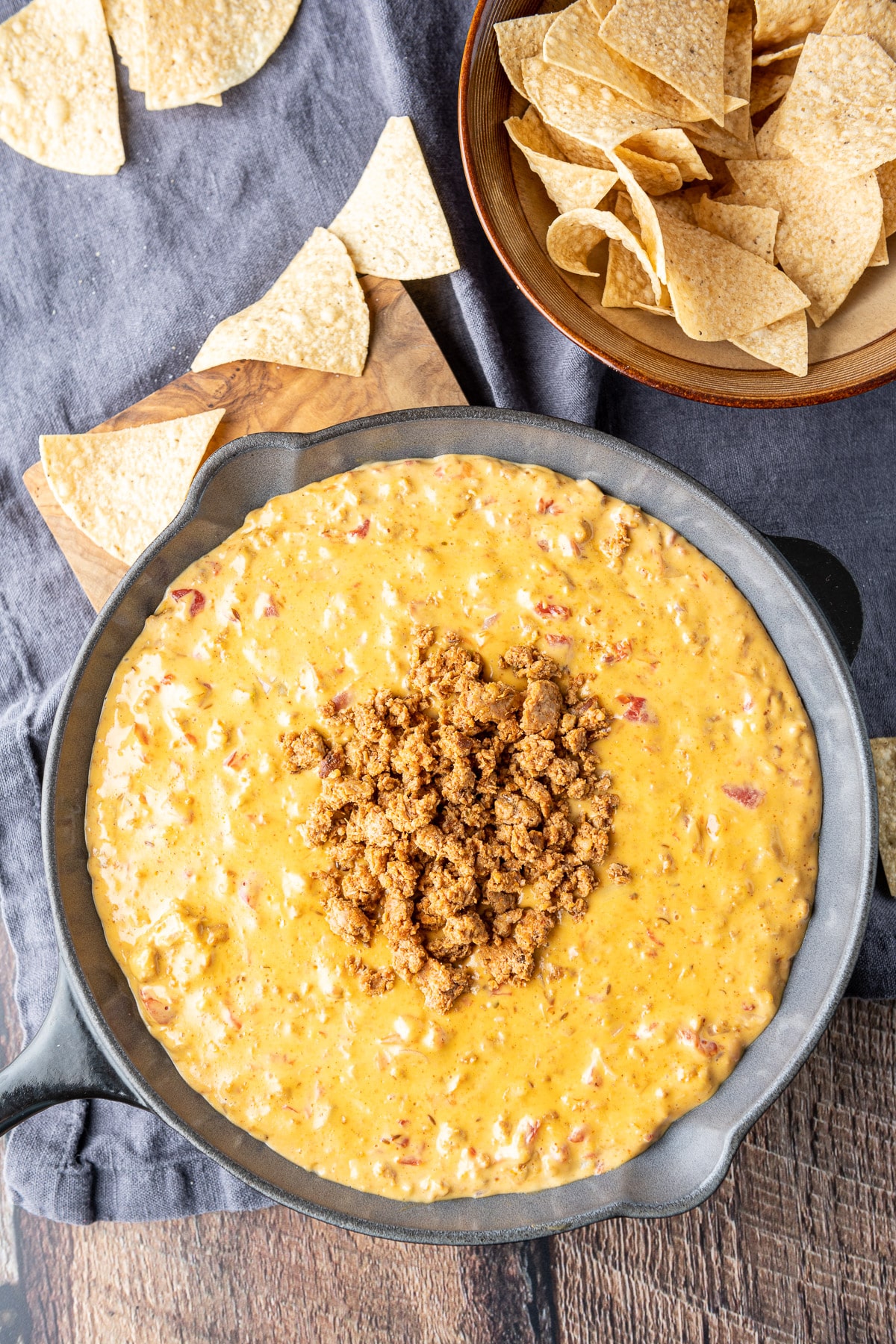Overhead view of the spicy dip with chips strewn on the table