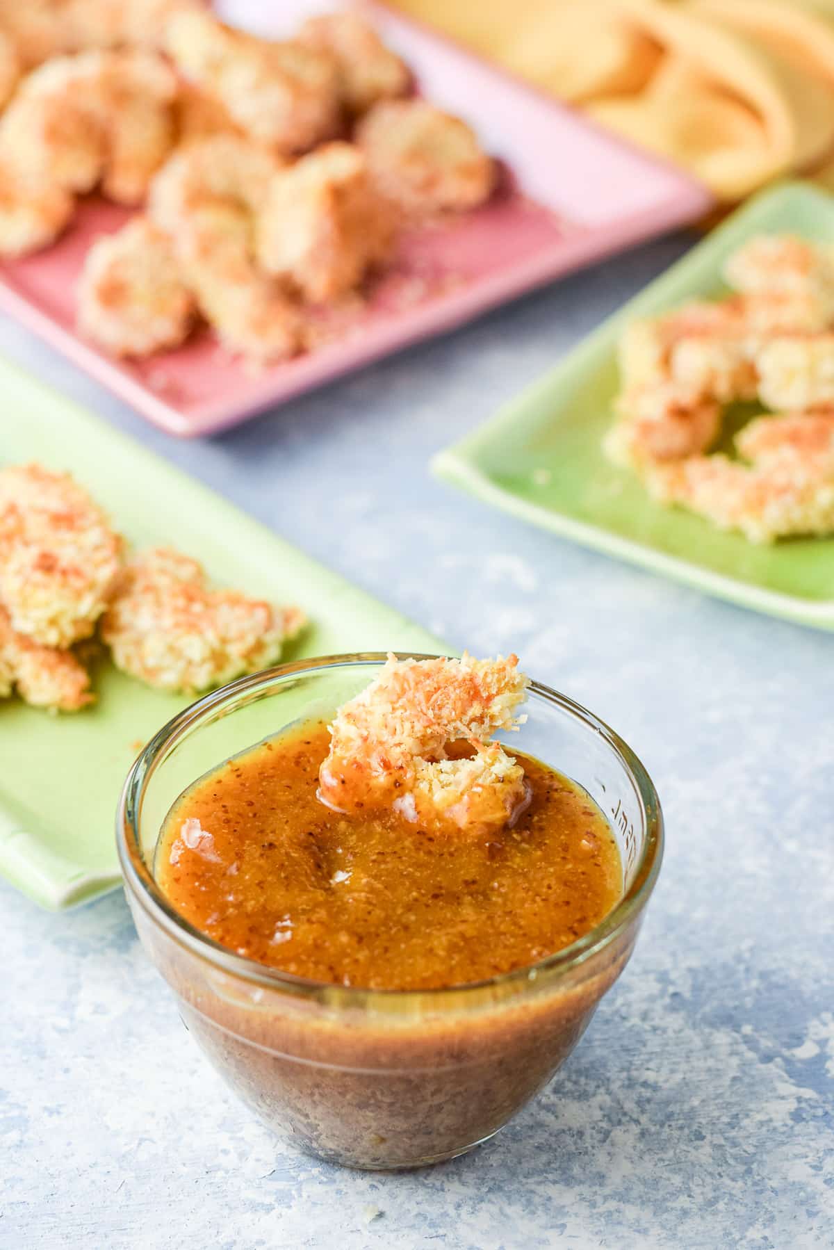 A baked shrimp in the apricot sauce with the appetizer in the back