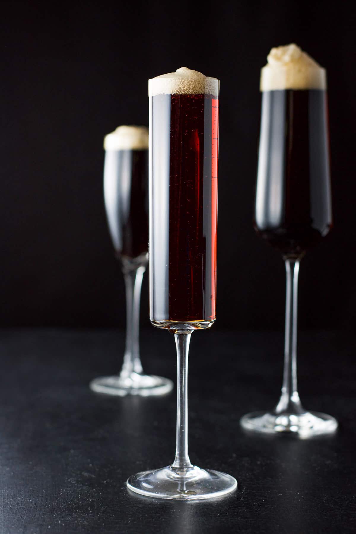 three glasses with the cocktail with one of them nearly behind the other