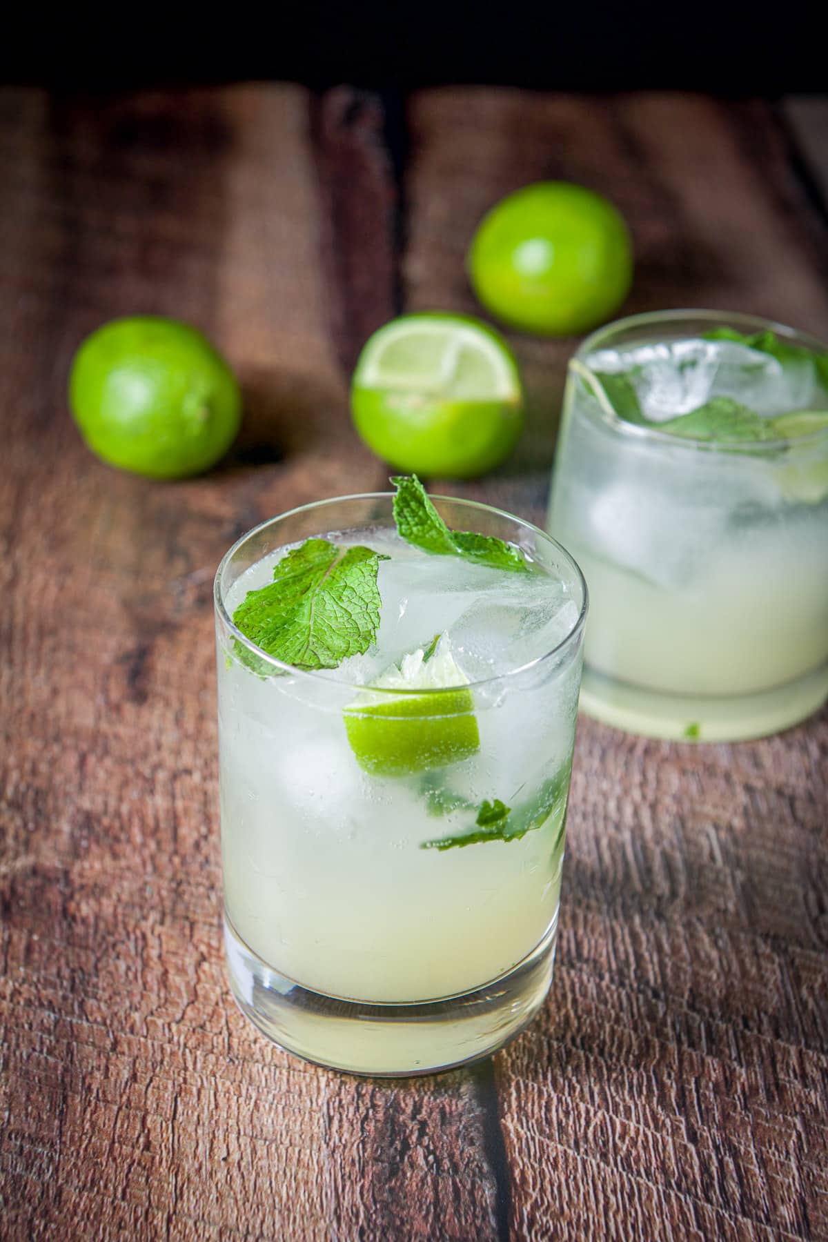 Lime wedges squeezed into the mojito glasses with limes in the back