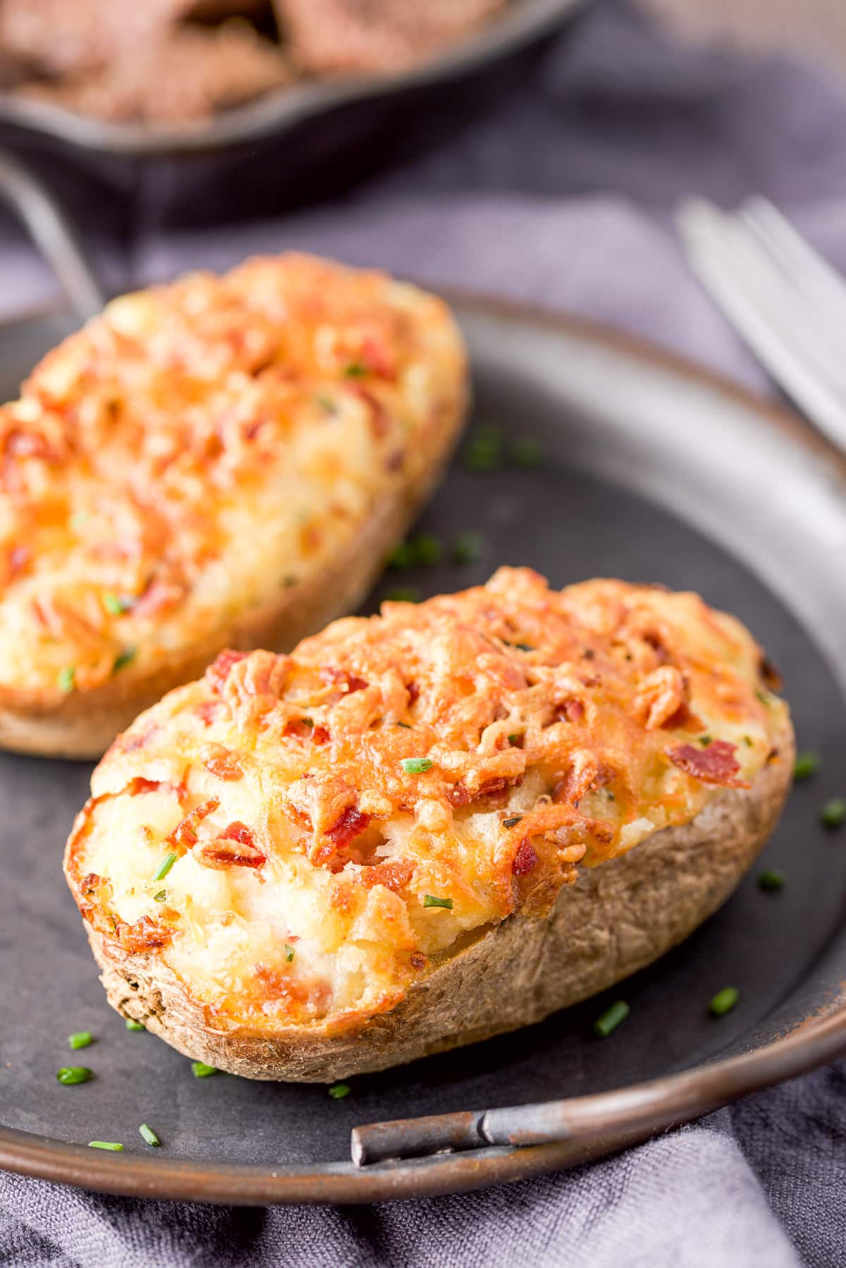 Two halves of a baked potato on a metal platter