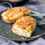 A metal platter with baked potatoes on it