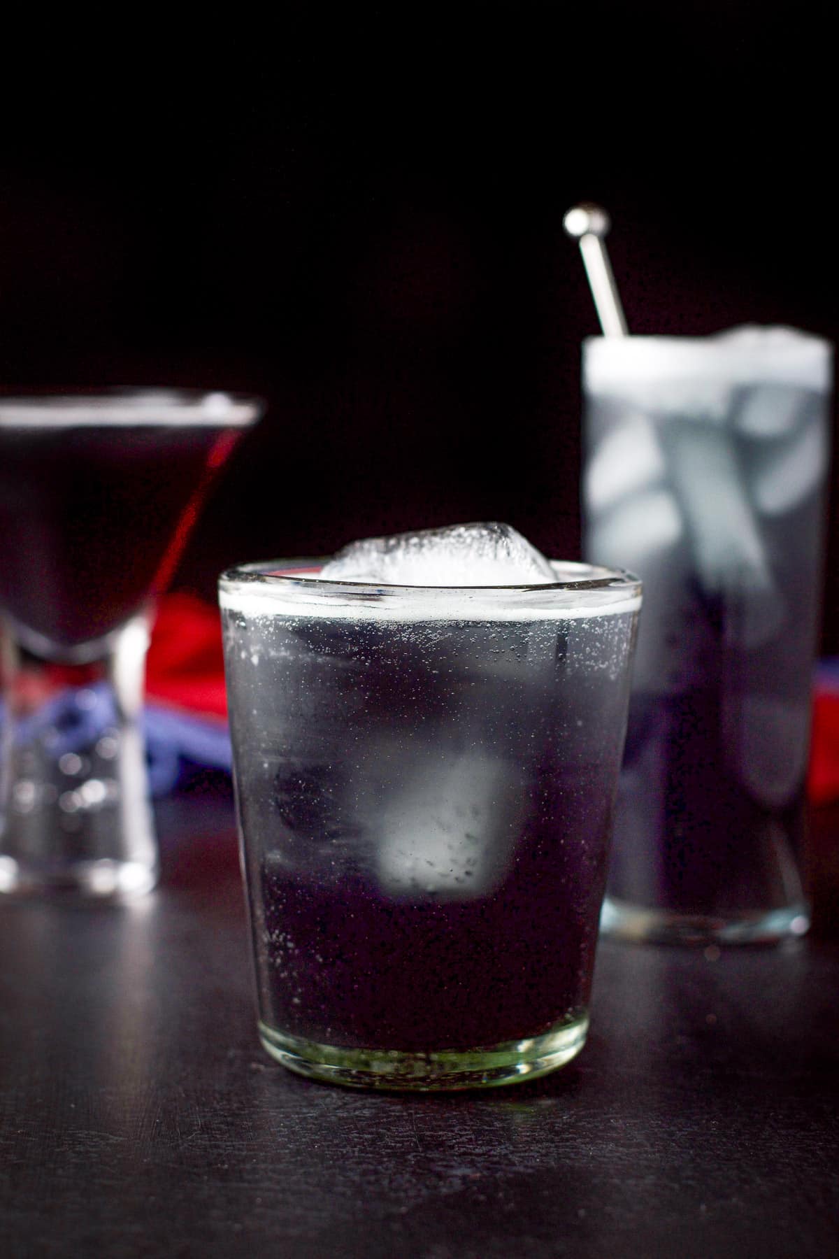 Vertical view of the shorter glass filled with the cocktail in front of the other two