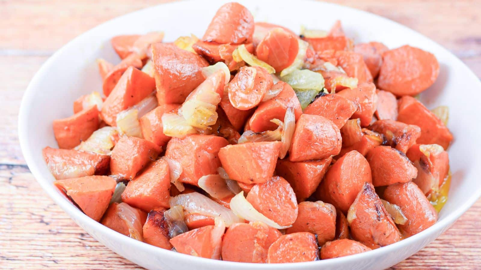 a white bowl with carrots and onions in it