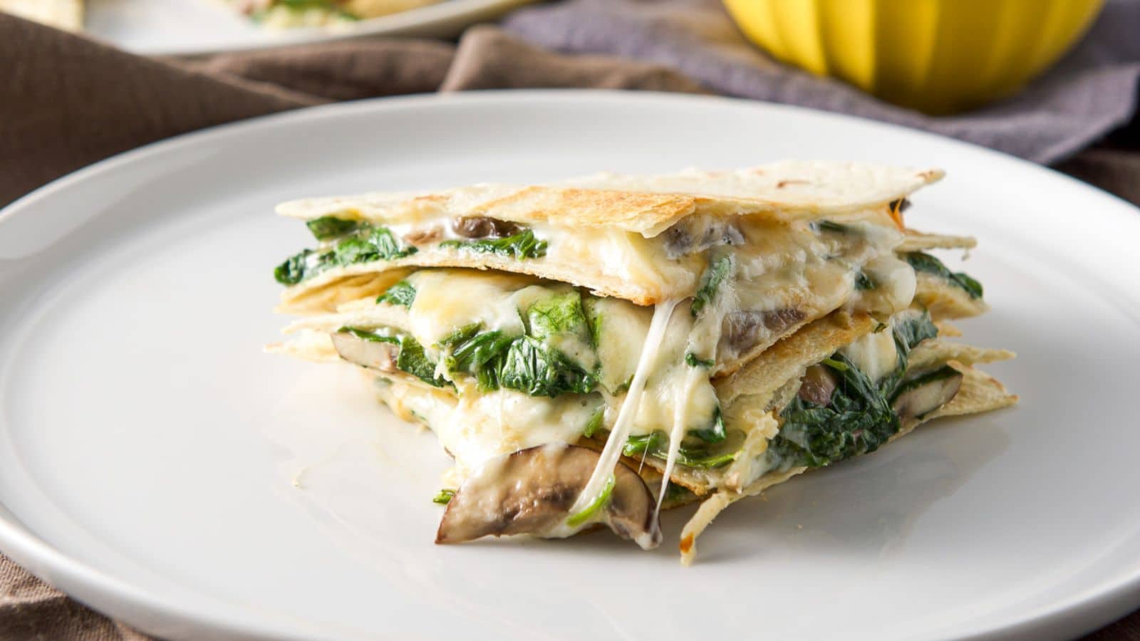 a plate with three quarters of a quesadilla piled on top of each other