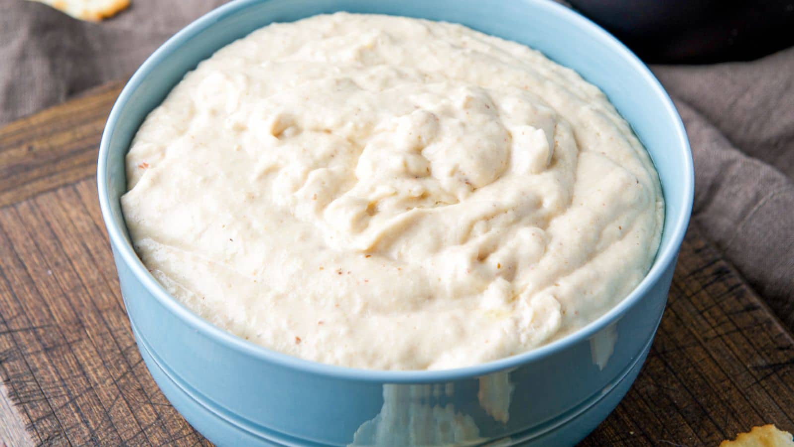 A blue bowl filled with a creamy dip