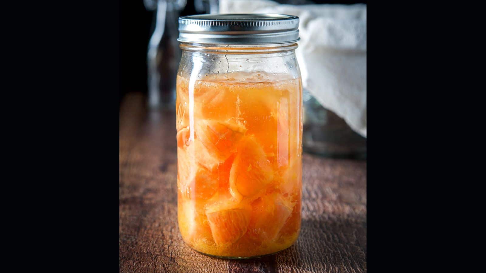 A jar with vodka and chunks of grapefruit