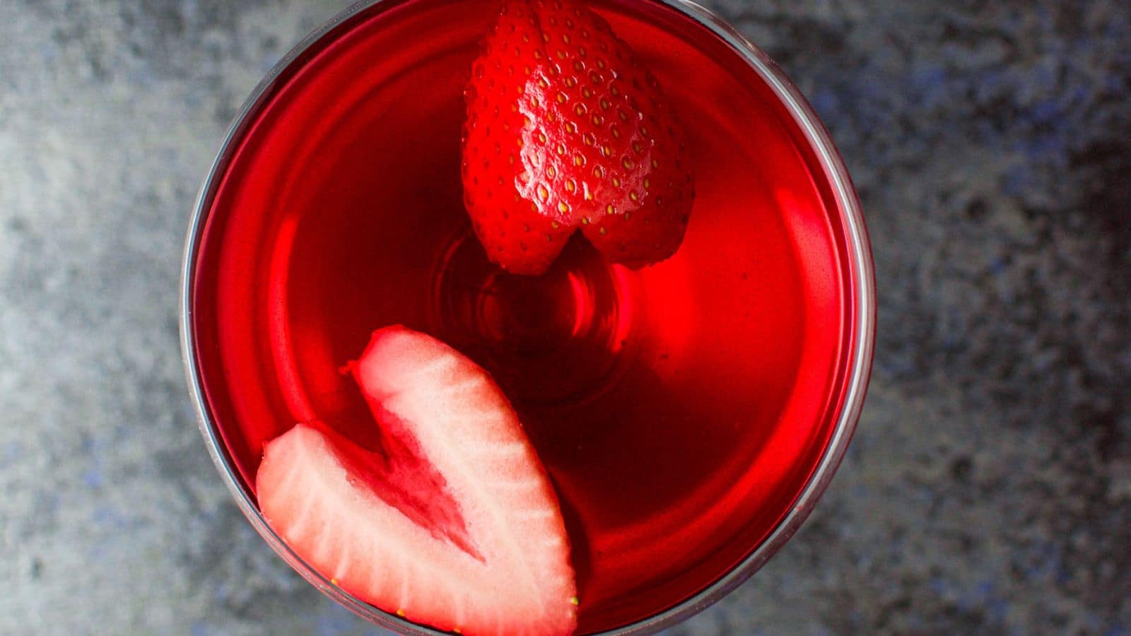 Overhead view of the red cocktail with strawberry slices floating on top