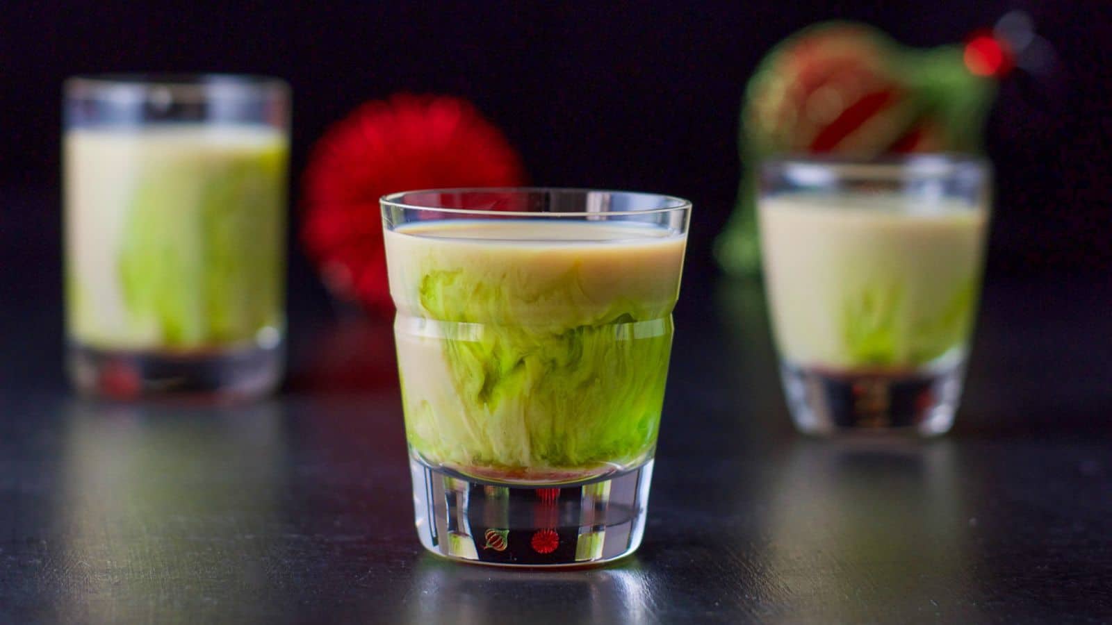 three glasses with a green and beige liqueur layered in it