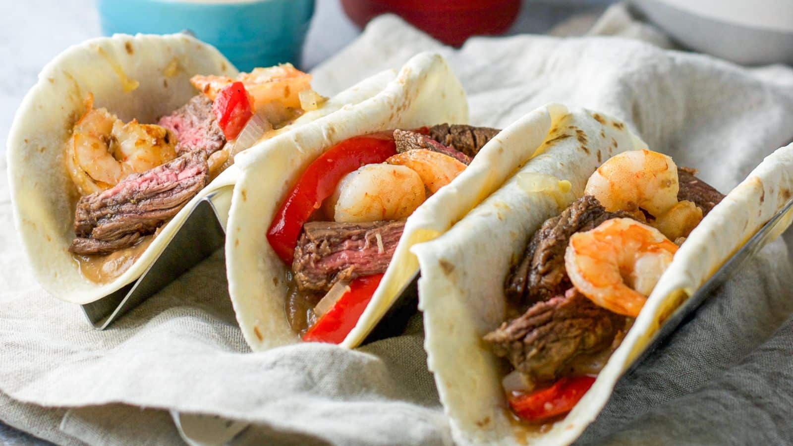Three flour tortillas filled with beans, vegetables, shrimp and steak