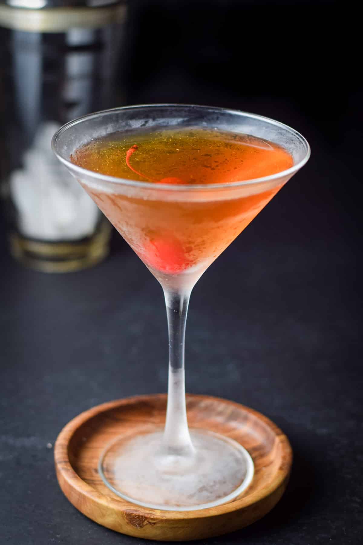 Rob roy in a frosty glass with a maraschino cherry in it