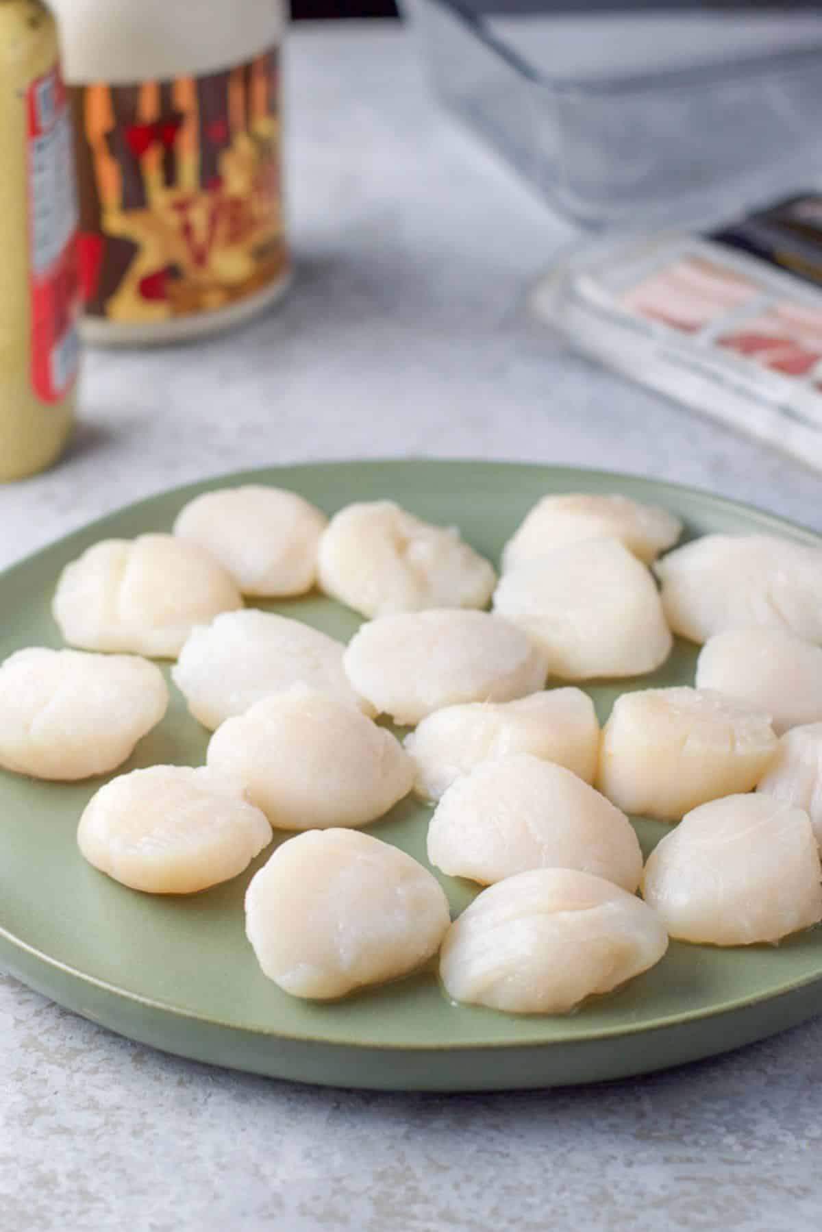 Scallops rinsed and patted dry with marinade ingredients in the background