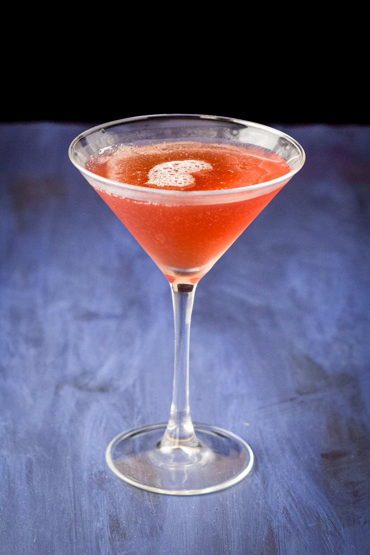 Closer view of the Châtelaine drink on a blue table and black background