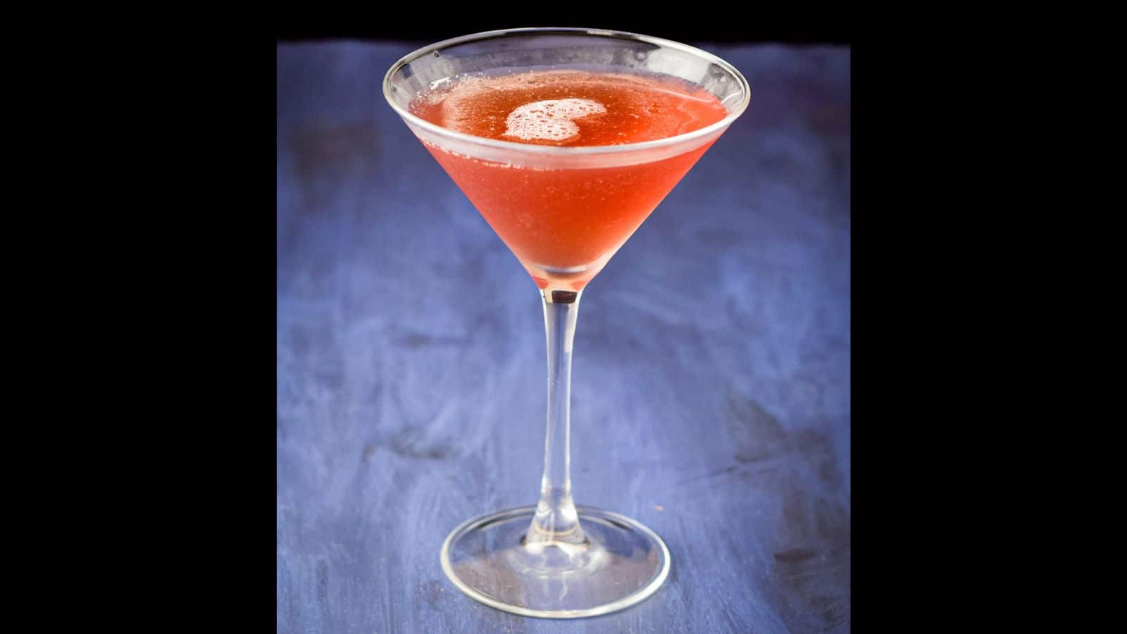 Closer view of the Châtelaine drink on a blue table and black background