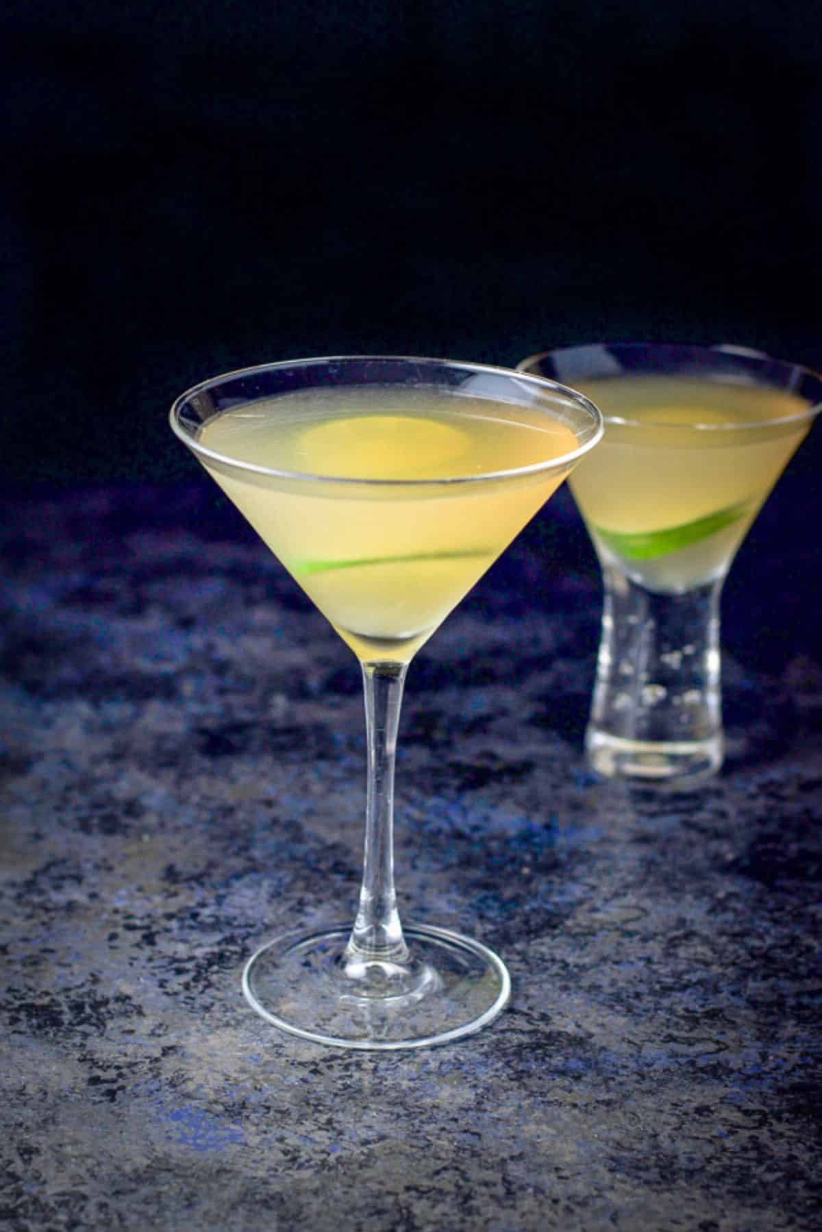 two martini glasses of the daiquiri cocktail on a blueish table