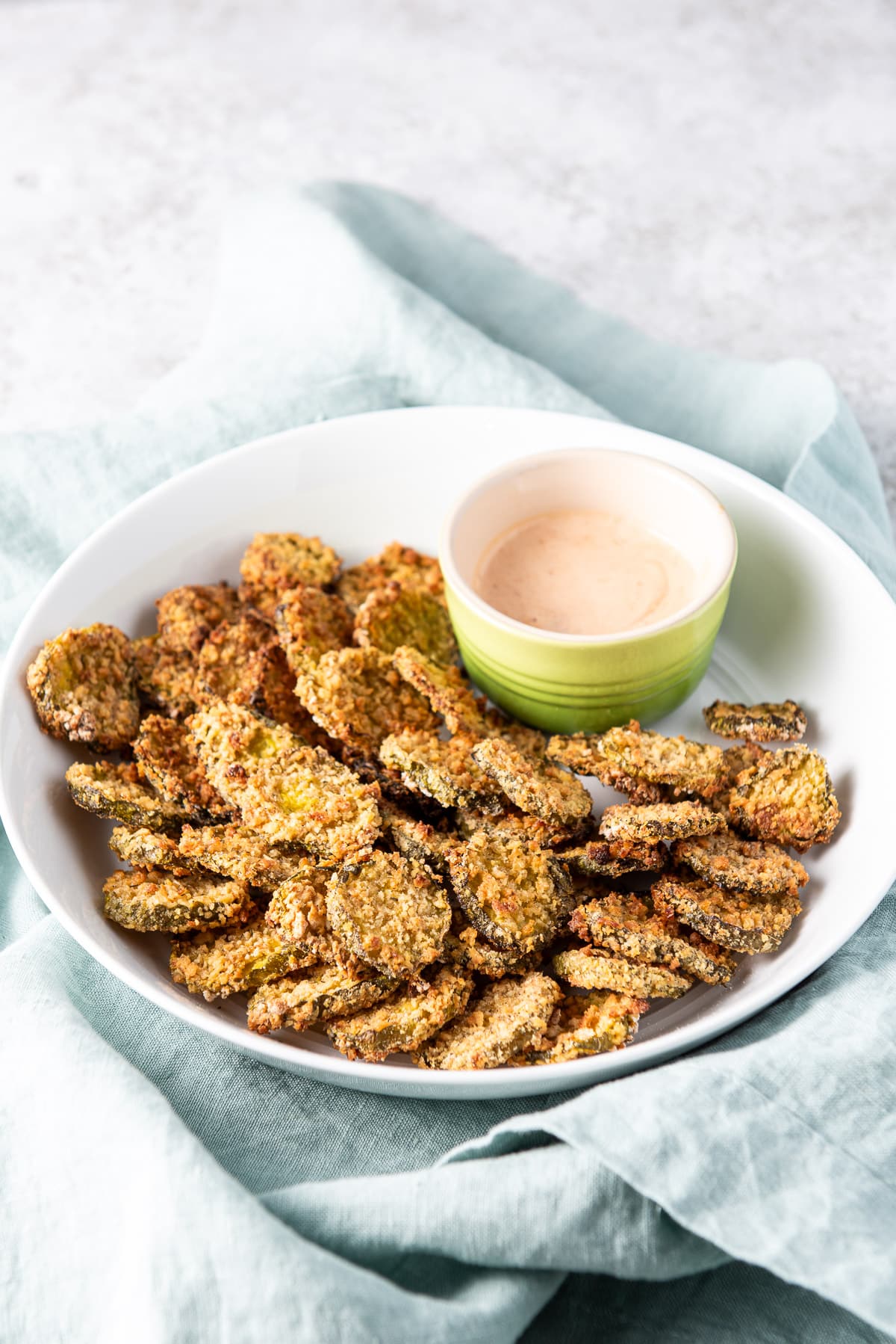 Air fryer pickles on a plate with the dip