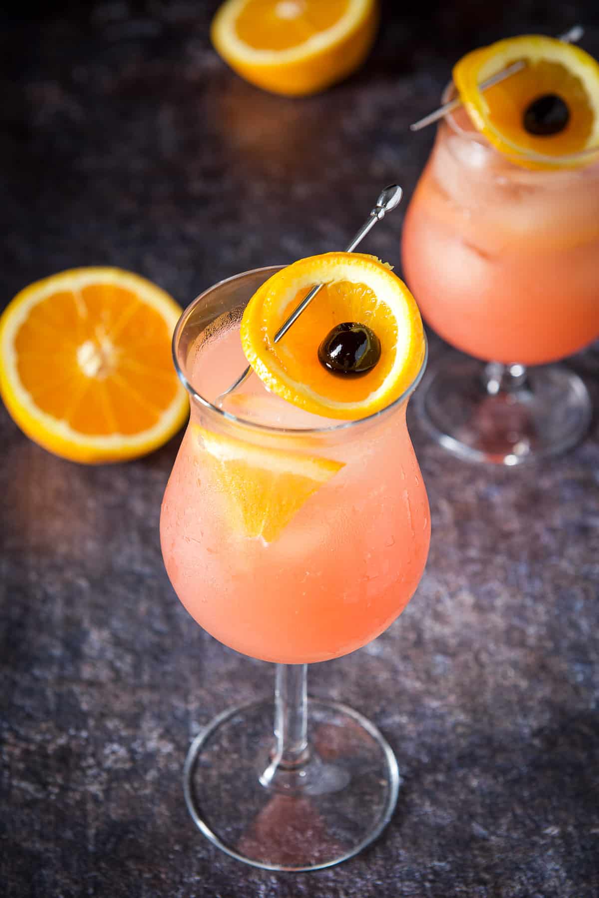 Perfectly balanced planter's punch cocktail ready to be drunk An orange and cherry in two tulip glasses with the cocktail in it