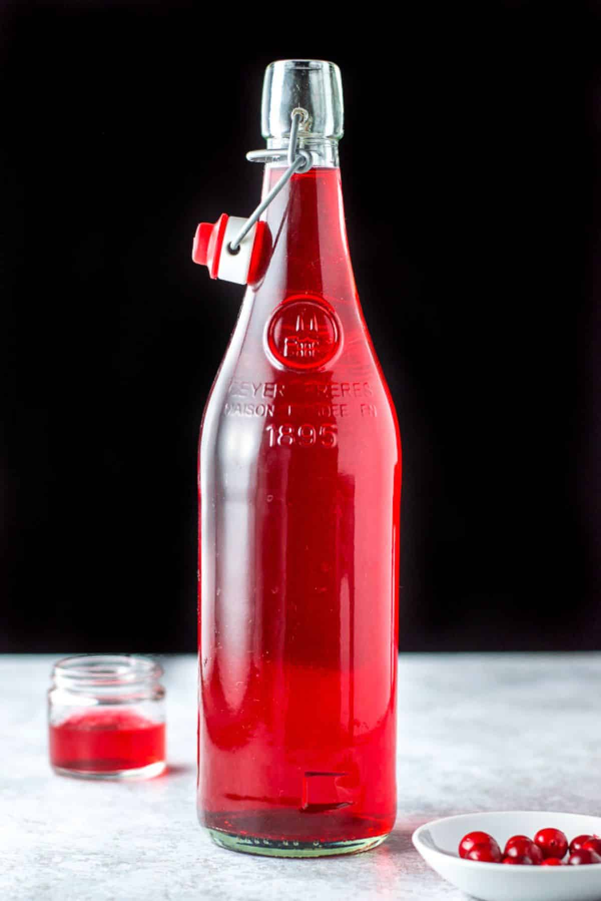 A vertical view of the bottle with the red vodka in it
