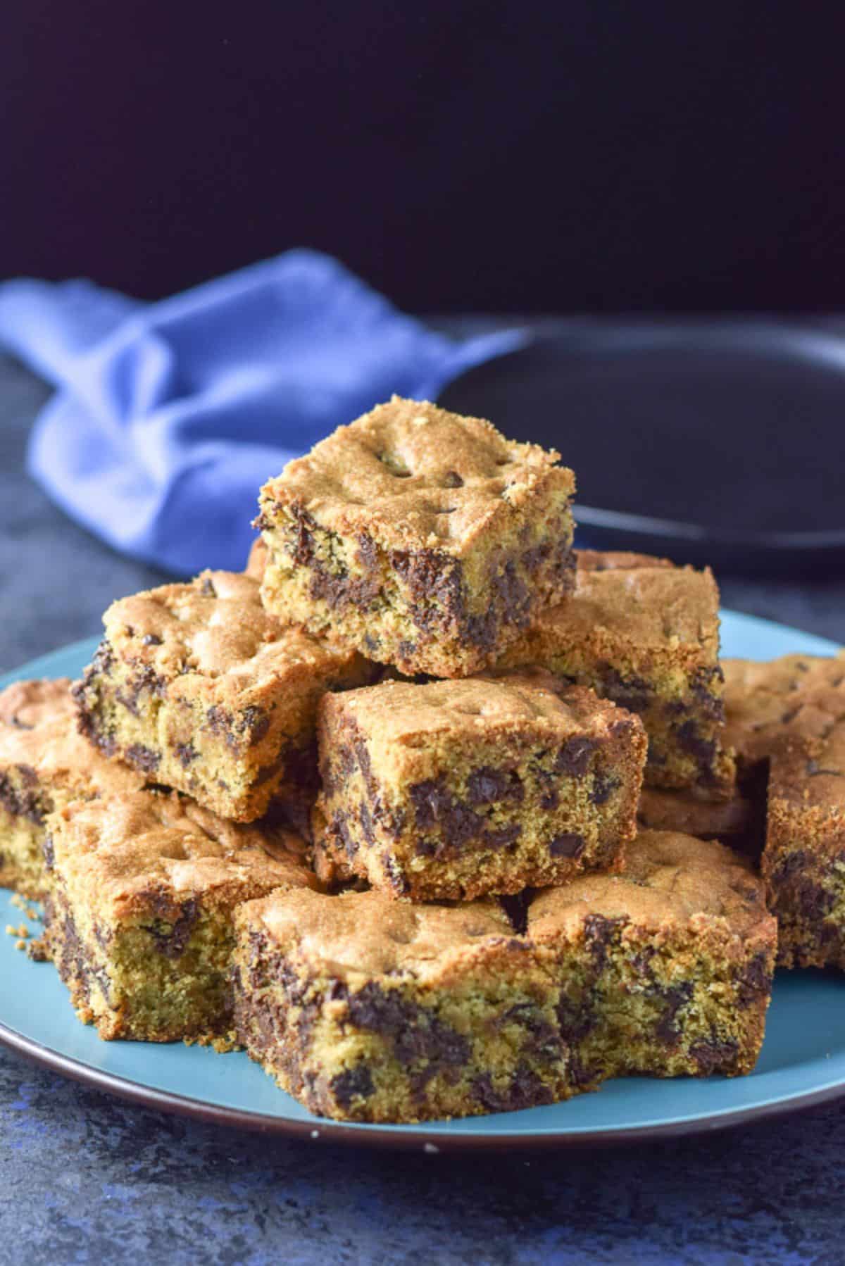 Blue plate piled with the chocolate chip bars cut into nice squares