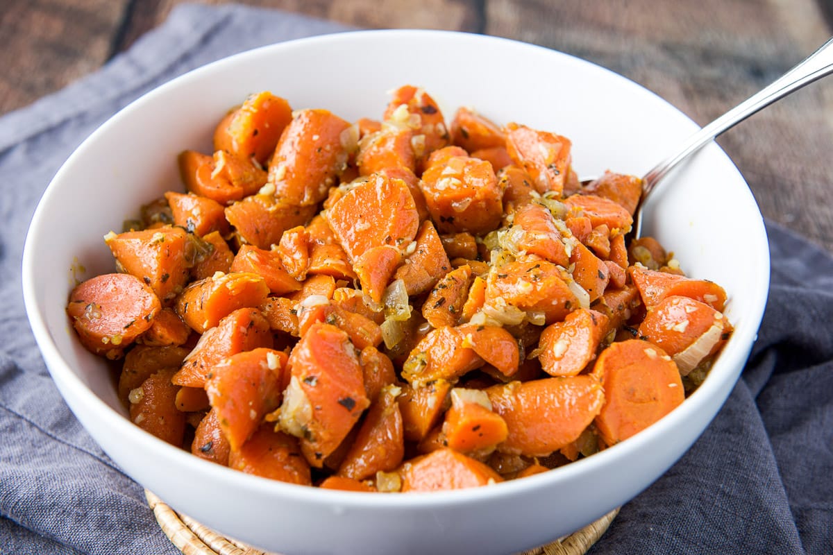 Horizontal photo of a white bowl with carrots and onions in it